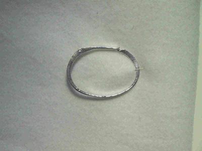 This bracelet is hammered silver, and is hinged with a rivet.  It will fit a medium-sized wrist. Sold