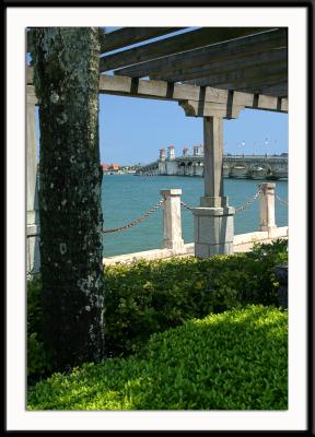 View of the St. Augustine bridge through an arbor in a city park in St. Augustine, Florida.