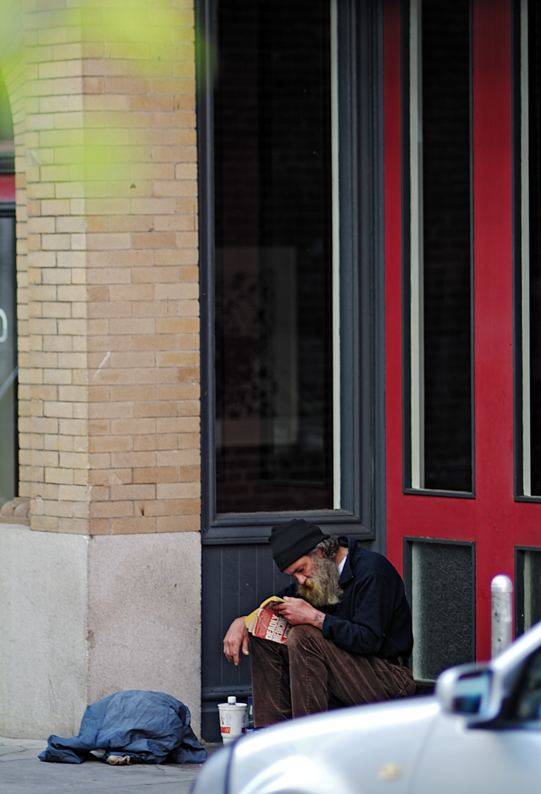 man reading in doorway of Aurobora Press
