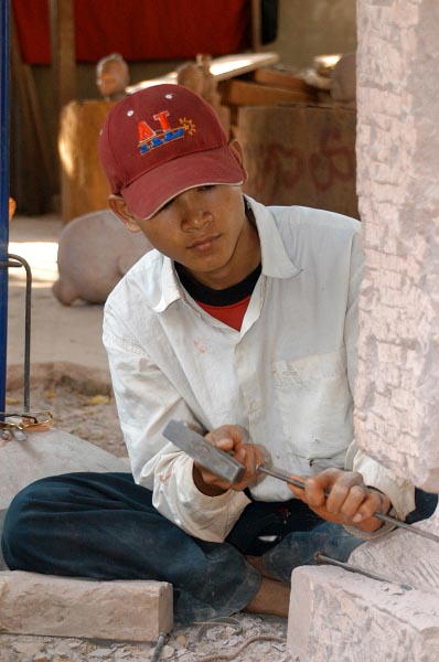 Stone carver working on a Standing Buddha, Cambodia