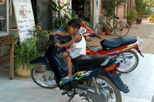 Young boy playing on a motor bike