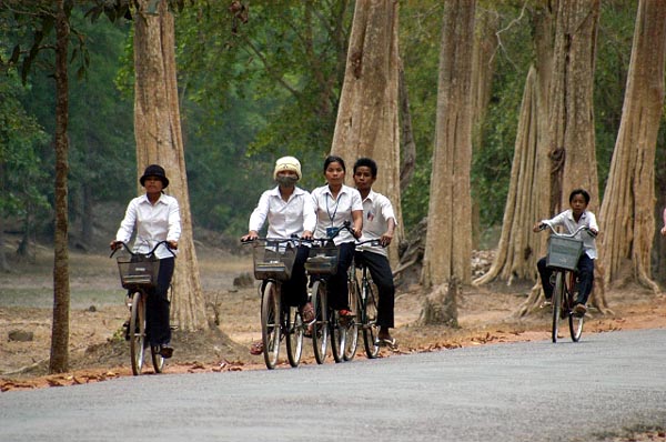 Locals cycling along the road to Bayon in Angkor Thom