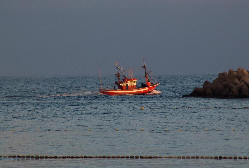 Red fishingboat leaving the port