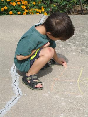 Son drawing chalk on patio
