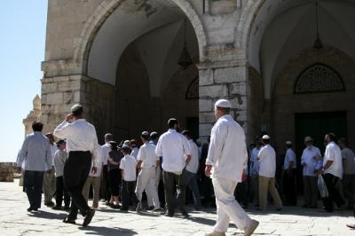 Jewish visitors walk past the Al Aqsa mosque.