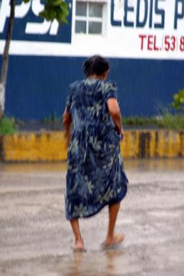 Driving into Petatlan, I photographed bare footed woman in pouring rain, while moving/driving from car window