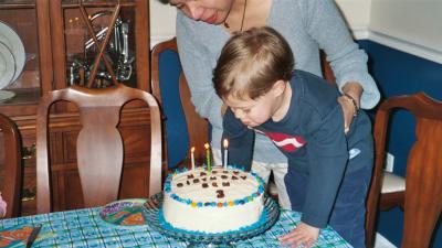Ben blowing out the candles on his cake at his 3rd birthday party