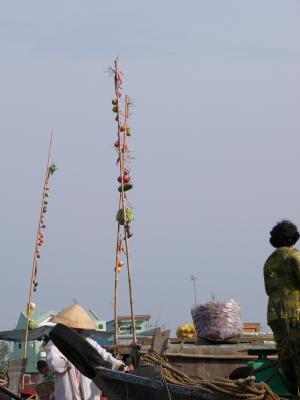 Each boat's wares are displayed on a bamboo pole