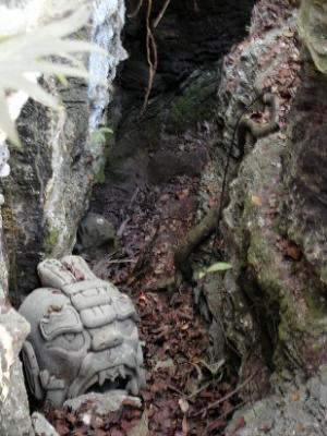 Crevice in the jungle with statue