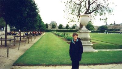 Judy in Tuileries Gardens on Right Bank headed for Orsay Museum (background) on Left Bank across Seine River.