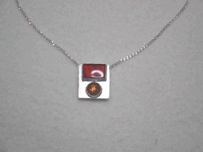 This pendant has a 12mm x 16mm rectangular carnelian above a 10mm round amber cabochon.  It can be worn with either the carnelian or the amber stone on the top.  SOLD