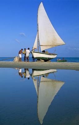 jangada com pescadores e reflexo na praia do Munda