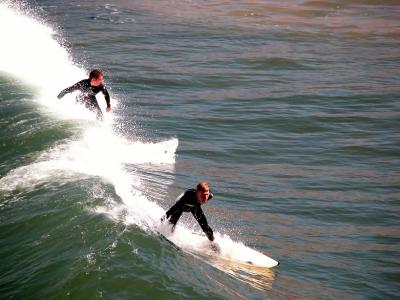 Surfers off the pier at Pismo Beach, CA