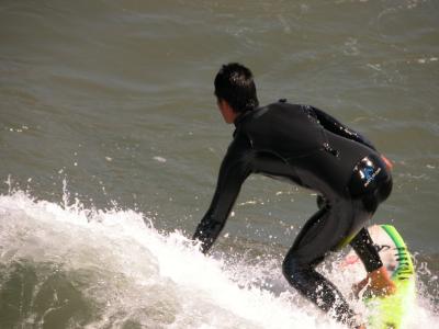 Surfer off the pier at Pismo Beach, California