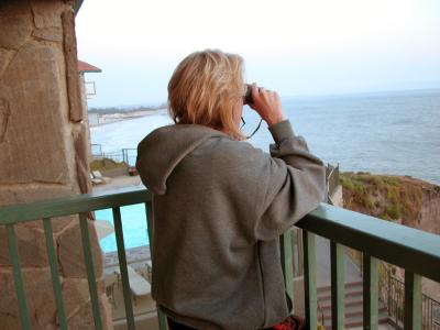 Laurie in the balcony with binoculars at Shore Cliff Lodge, Pismo Beach, CA