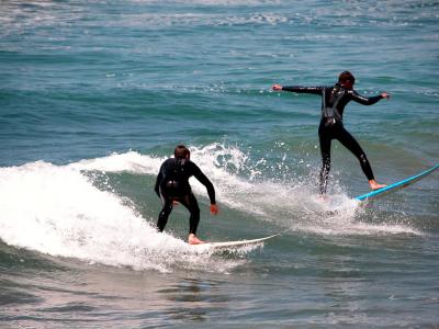 Surfers off the pier at Pismo Beach, CA