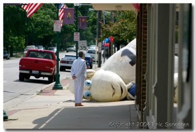 Senior Citizen Observing Giant Sheep on Main Street