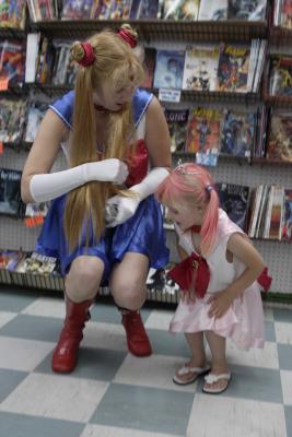 Sailor Moon helps Chibi Moon up.