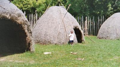 Ben standing in front of a teepee at the Indian Village