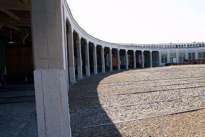 Locomotives and rail cars in maintenance bays in the roundhouse. Note the radial rails leading to each bay.