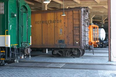Rail cars in maintenance bays in the roundhouse. Some have been restored, some are waiting to be restored.