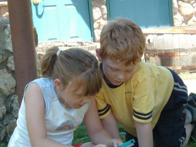 The kids relax in the shade with thier gameboy.