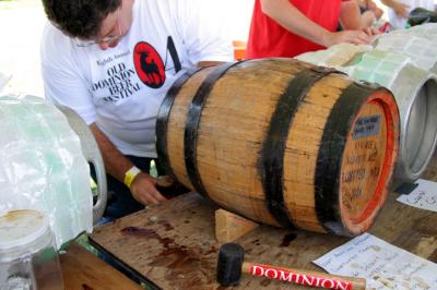 Volunteer Lloyd Dolan taps a sample of Sweetwater Tavern's award-winning Imperial Stout.