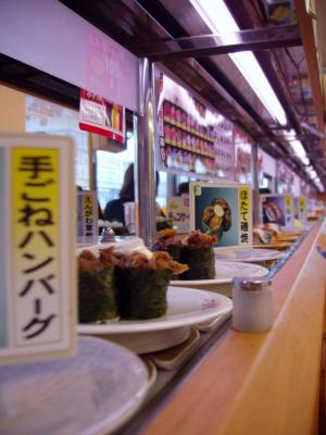 ...on a conveyor belt.  Patrons pick and choose.  Each plate is 100 yen or so - it's very easy to come out with a huge bill!