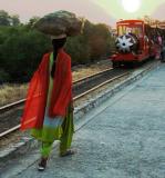 Woman carrying a load and the tourist train