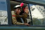 Indian NCC cadet waves from a passing bus