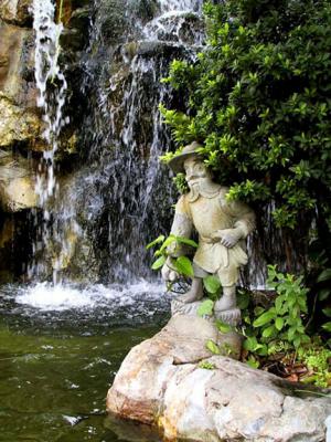 Small statue by waterfall