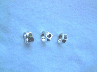 Various styles of platform rings.  From left to right: peridot on a low platform, iolite on a polished square platform, and labradorite on a reticulated square platform.