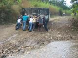 men trying to push the truck up the hill