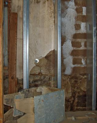 Old wall behind the modern aluminum reinforcement