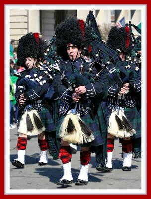 Mixed Gender Bagpipers Sporting Knit Red Plaid Stockings and Ankle Supports