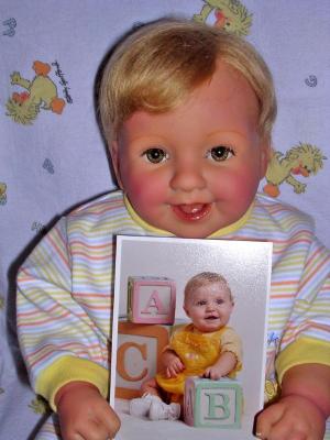 Baby Alex holding a picture of the baby she was made to look like.