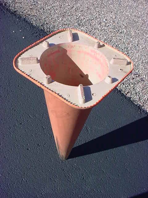 cone standing on head<br> on blacktop pavement