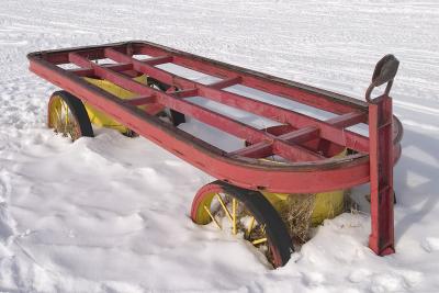 Red cart in snow along bank
