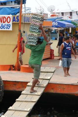 Man carrying eggs to load on Amazon River boat