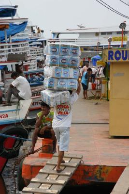 Man carrying toilet paper to load on Amazon River boat