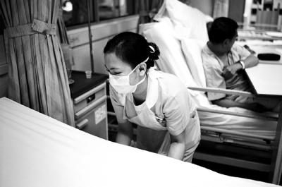 Nurse Adjusting Bed Linen