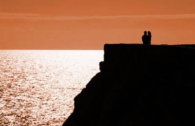 couple embracing, sunset ocean