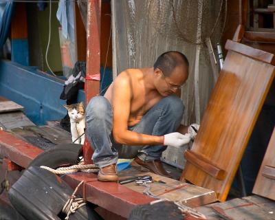 Working on the houseboat while the cat looks on