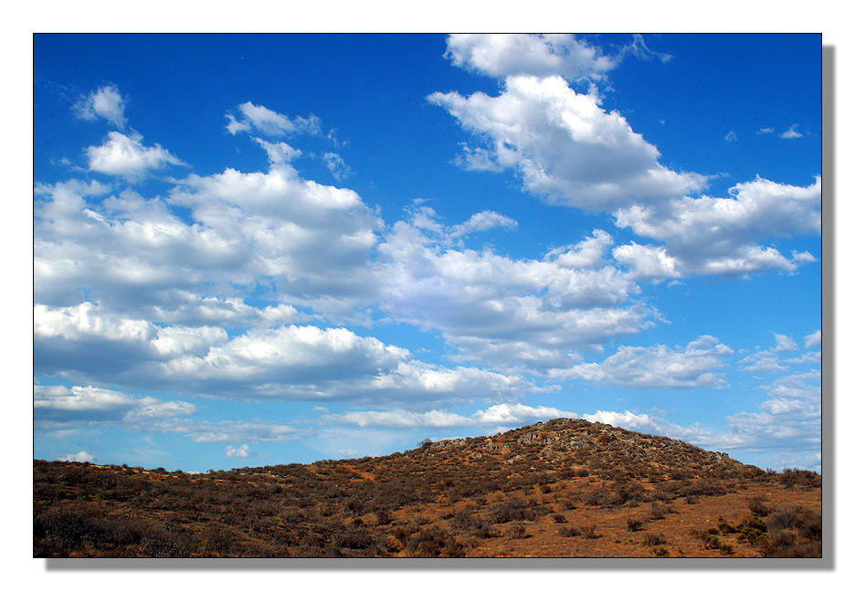 blue skies over desert by mark dominic