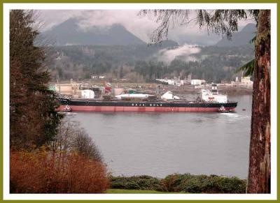 2 tugs docking a large freighter.