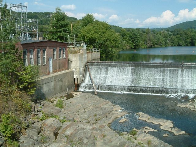 Power plant with dam next to covered bridge