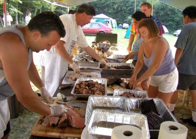 Christian, Rick, Alison, and Alan Hew carve the smoked meats