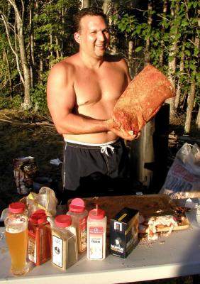 On Friday afternoon, Christian Parker prepares meats for the smokers for MASHOUT's big Saturday nite potluck BBQ dinner