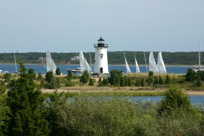 The Edgartown Lighthouse surrounded by sailboats in the harbor.