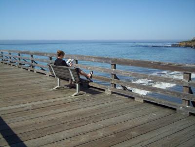 woman reading on pier